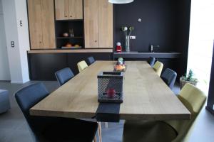 a dining room with a wooden table and chairs at La Couture du Charme in Saméon