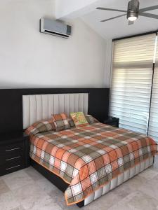1 dormitorio con 1 cama y ventilador de techo en Casa Bonita cerca de playa, en Bucerías