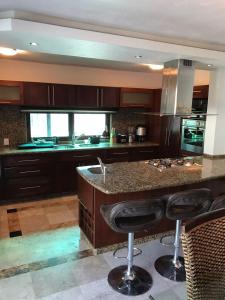 a kitchen with a island with bar stools at Casa Bonita cerca de playa in Bucerías