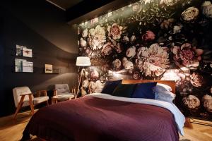 a bedroom with a floral wall with a bed at FOUR STORIES APARTMENTS - Krasinskiego in Krakow