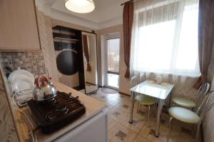 a kitchen with a stove and a table with a tea kettle at Guest House Parusnik in Alushta