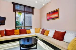 a living room with a couch with colorful pillows at Le Petit Fillan in Johannesburg