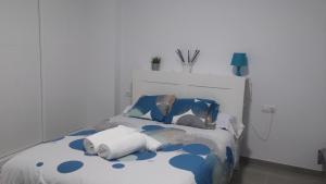 Cama con sábanas y almohadas azules y blancas en Benalbeach Apartment Ana, en Benalmádena