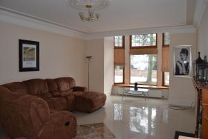 a living room with a brown couch and windows at Amazing 4 Bed Scottish Baronial Style House in Westhill