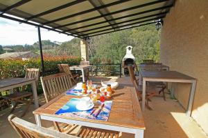 una mesa y sillas en un patio con vistas en Chambres d'hôtes Multari, en Patrimonio