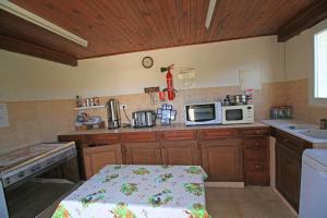a small kitchen with wooden cabinets and a microwave at Chambres d'hôtes Multari in Patrimonio +14 photos