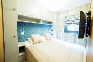 a bedroom with a bed with a blue headboard at Home Again Apartments Nygata 16 in Stavanger