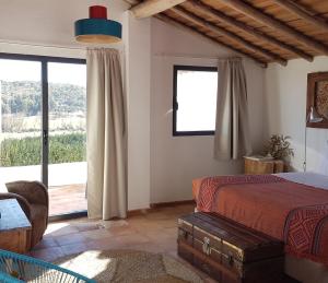 a bedroom with a bed and a large window at Herdade da Maxuqueira in Gavião