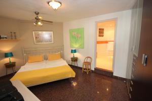 een slaapkamer met een bed met gele lakens en een schuifdeur bij Casa Lodge Finca Alcalá in Alcalá