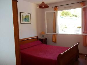 Les FEICHES et MARGUERITES في Ignaux: غرفة نوم بسرير احمر ونافذة
