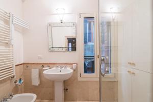 uma casa de banho com um lavatório e uma cabina de duche em vidro. em Romantic Suite San Marco em Veneza