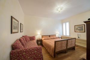 a bedroom with a bed and a couch at Romantic Suite San Marco in Venice