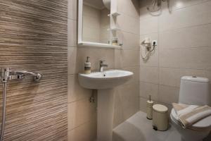a bathroom with a sink and a toilet and a mirror at Athina Apartments Near The Sea Platania in Plataniás +9 photos