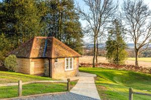 a small house in a field with a fence at Cowdray Lodge B&B rooms in Midhurst