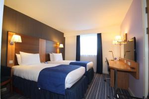 a hotel room with two beds and a desk at Holiday Inn Express Nuneaton, an IHG Hotel in Nuneaton