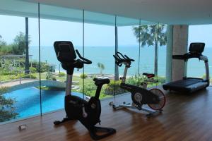 un gimnasio con vistas a una piscina y bicicletas estáticas en The Palm Wongamat Beach Pattaya en Pattaya North