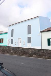 un edificio bianco con finestre sul lato di una strada di Cantinho Das Praias a Vila Franca do Campo