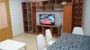 een kamer met een tafel en een tv in een kamer bij APARTMENTSUITESPAIN Beach Economy in Valencia