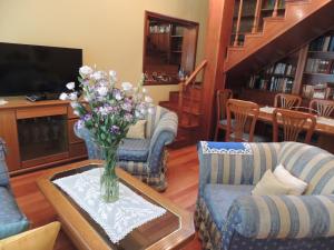 una sala de estar con un jarrón de flores sobre una mesa en La Ribera Home & holidays en Martínez