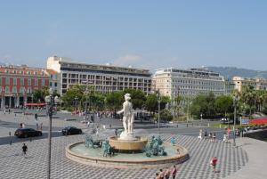 uma estátua no meio de uma praça com pessoas em Hotel De La Mer em Nice
