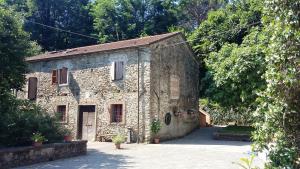 an old stone building in the middle of trees at B&B Ai Chiosi in Pontremoli