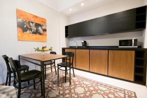 een keuken met een tafel en stoelen in een kamer bij Il Fuoco di Archimede - Ortigia in Siracusa