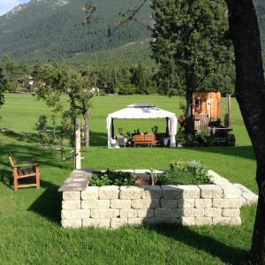 einen Hinterhof mit einem Zelt, einem Tisch und einer Bank in der Unterkunft Apart Gaberhof in Tarrenz