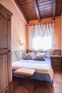 a bedroom with a large bed with a window at Casas Rurales La Dehesa in Casas del Monte