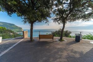 a park bench sitting between two trees on a patio at Rinaldi's Apartment in Sirolo