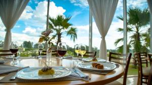 a table with plates of food and wine glasses at Otho Hotel Convention & SPA in Itu