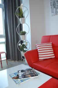 sala de estar con sofá rojo y plantas en ENJOY CANTERAS Apartamento, en Las Palmas de Gran Canaria