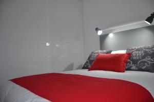 ラスパルマス・デ・グランカナリアにあるENJOY CANTERAS Apartamentoのベッドルーム1室(赤い枕付きのベッド1台付)