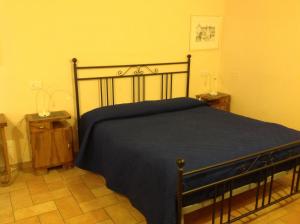 a bedroom with a bed with a blue blanket at San Francesco Bedrooms in Urbino