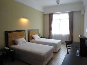 Postel nebo postele na pokoji v ubytování Puteri Bay Hotel