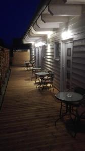 a row of tables and chairs on a deck at night at Pension König in Kassel