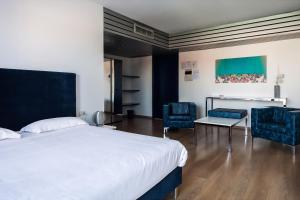 1 Schlafzimmer mit einem Bett, 2 Stühlen und einem Tisch in der Unterkunft Park Hotel Residence in Crema