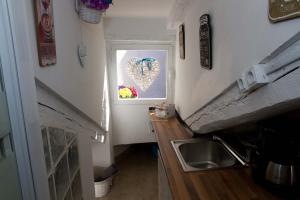 una cocina con fregadero y una ventana con una foto del corazón en Buhardilla Corazon de Malasana, en Madrid