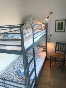 a pair of bunk beds in a room with a chair at Haus Fischernetz in Leezdorf