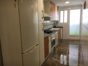 a kitchen with a white refrigerator and a sink at Apartament Magnífico in Paiporta