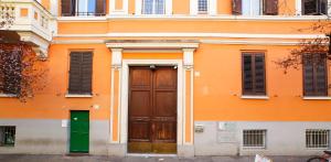 ローマにあるCastel Sant Angelo's Harmonious Apartmentの緑の扉と窓のあるオレンジ色の建物