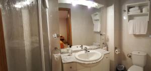a white bathroom with a sink and a toilet at Enginyapartaments in Figueres