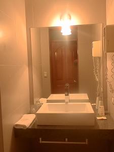 a bathroom with a sink and a large mirror at Samana Hotel in Arequipa