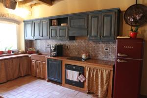 a kitchen with black cabinets and a red refrigerator at Relais Corte Sant' Agata B&B in Verona