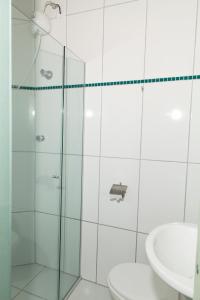 a bathroom with a shower and a toilet and a sink at Hotel Oasis in Contagem +7 photos