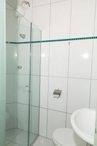 a bathroom with a shower and a toilet and a sink at Hotel Oasis in Contagem