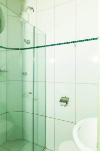 a bathroom with a glass shower and a sink at Hotel Oasis in Contagem