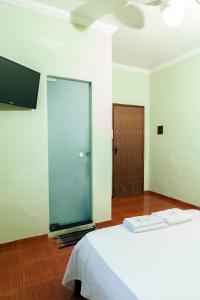 a bedroom with a bed and a sliding glass door at Hotel Oasis in Contagem