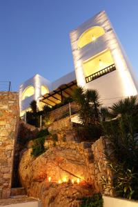 a house on a hill with lights on it at Vrahos Boutique Hotel in Karavostasi