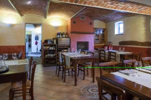 a restaurant with tables and chairs and a fireplace at La Vigna Del Maestro in Bene Vagienna