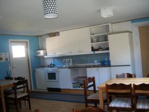 a kitchen with white cabinets and a table and chairs at Söderhagen Camping och Gästhem in Eckerö